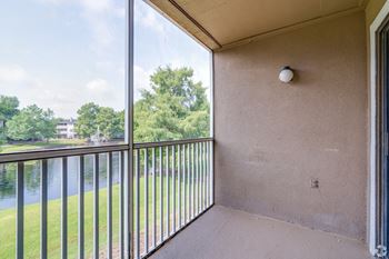 a balcony with a view of a river and trees
